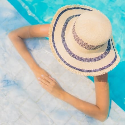 A woman with a sun hat in a pool.