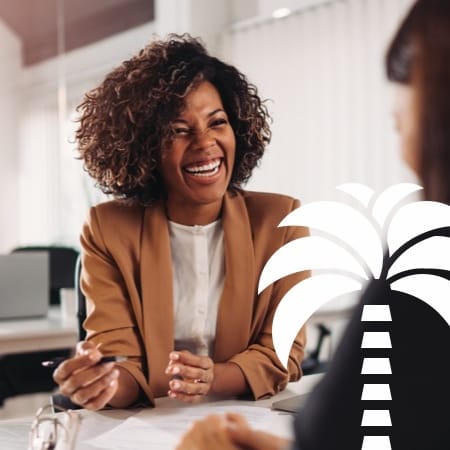A young woman professional sitting at a table smiling.