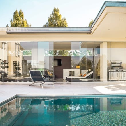 Patio view of a modern home with a pool.