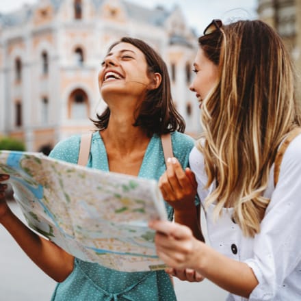 Two women travelers looking at a map.