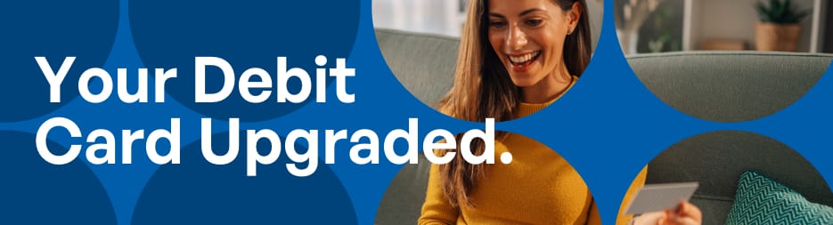 Woman smiling while holding a debit card at home on a blue graphic background. At the left, the words: your debit card upgraded.