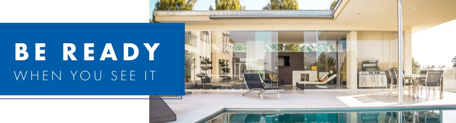 A living room view from the patio of a modern, one-story home. Centered at the left, the words: be ready when you see it.