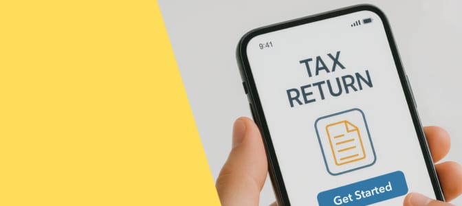 A hand holding a mobile phone showing a tax return screen.