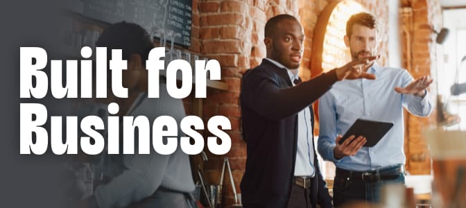 Two business professionals reviewing plans together inside a modern cafe setting. To the left, the words: built for business.