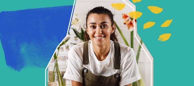 A smiling young woman business owner in an apron.