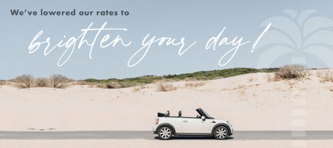 A BMW Mini Cooper parked on the beach. At the top, the words: We've lowered our rates to brighten your day!