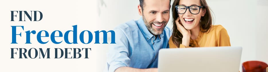 A young couple smiling while looking at a laptop. At the left, the words find freedome from debt.