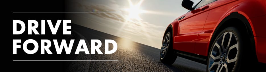 A side shot of a red car with the sun setting in the background. At the left, the words: Drive Forward.