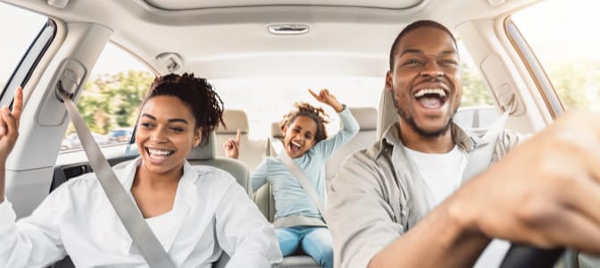 A happy family inside a car.