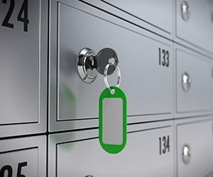 A key with a green keychain tag opening a safety deposit box